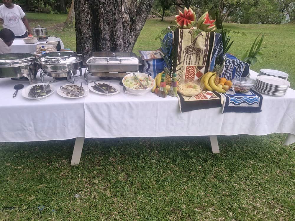 A buffet laid out under the trees at the jetty