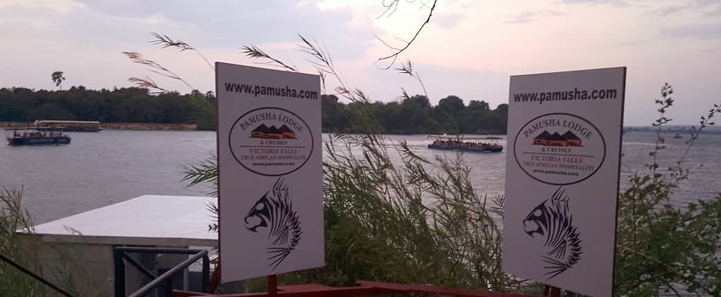 Pamusha Lodge & Cruises signs at the jetty on the Zambezi